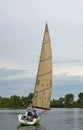 Yacht on water with crew on board and raised sails.