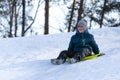 Cherkasy, Ukraine -01.05.2019 Boy sledding down the hills on a winter day.