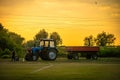 Cherkasy, Ukraine - May 19, 2020:Tractor Belarus with a trailer. Tractor drivers in the field against the background of sunset