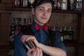 Handsome bartender making drink with sheker in bar