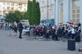 Brass band accompanies singer building outdoors.