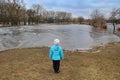 Child watching river flooding in city after melting snow in spring. Natural disaster Royalty Free Stock Photo
