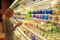 Woman makes her choice in the shop of dairy products