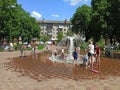 Children have a fun with city fountains in hot summer day