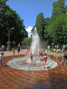 Children have a fun with city fountains in hot summer day