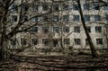 Street of the abandoned ghost town Pripyat. Overgrown trees and collapsing houses in the exclusion zone of the Chernobyl nuclear d