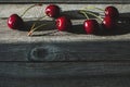 Cherries arranged in a row on wooden table in a streak of light