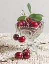 Cherries in the beautiful crystal vase on the lace tablecloth