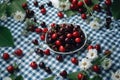 Cherries on blue checkered plaid in garden, summer fruit picnic. Generative AI