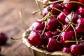 Cherries. Fresh sweet cherries. Delicious cherries with water drops in retro bowl on old oak table Royalty Free Stock Photo