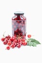 Cherries beside jar of cherry compote on white background Royalty Free Stock Photo