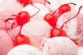 Cherries between many white and red ice cream scoops