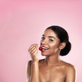 Cherries are my happy drugs. a beautiful young woman eating a cherry against a pink background. Royalty Free Stock Photo