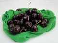 Fresh cherries fruits wrapped in cloth on green background Royalty Free Stock Photo