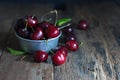 Cherries are placed in the zinc cup and put on a rustic wooden floor. Royalty Free Stock Photo