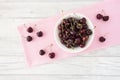 Cherries in a Bowl on Pink Fabric and White Wood Royalty Free Stock Photo