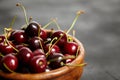 Cherries in a brown wooden bowl on a black stone table. Red ripe berries on a dark background Royalty Free Stock Photo