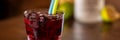 Cherry alcohol drink with color straws on wooden table Royalty Free Stock Photo