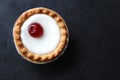 Cherry bakewell tart in foil case on dark background Royalty Free Stock Photo