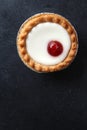 Cherry bakewell tart in foil case on dark background Royalty Free Stock Photo