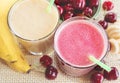 Cherry and banana smoothie with fresh cherries and bananas. Cherry milkshake. Banana milkshake. Fresh green leaves.