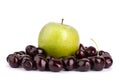 Cherry berries and one big green apple on white background isolated close up macro