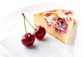 Cherry berries and piece of cream fruit pie on white plate close-up