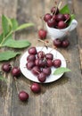 Cherry berries in raindrops lie in a saucer on a wooden table