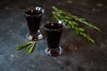 cherry, berry tincture on a dark background, with a sprig of rosemary Royalty Free Stock Photo