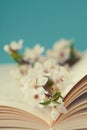 Cherry blossoms and old book on turquoise background, beautiful spring flower, vintage card Royalty Free Stock Photo