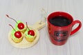 Cherry cakes and a cup of hot coffee on the table Royalty Free Stock Photo
