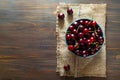 Cherry in ceramic bowl on burlap texture on wooden background with sunlight, sweet summer food.Flat lay, copy space, closeup Royalty Free Stock Photo