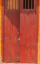 Cherry coloured stained ancient door with bars on windows,open