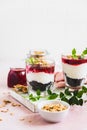 Cherry, cream cheese and chocolate biscuit portion layered dessert in glass, pink background. Black forest trifle. Summer dessert