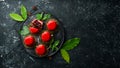 Cherry cream-mousse dessert with cherries and mint on a black stone plate. Top view. Rustic style Royalty Free Stock Photo