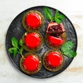 Cherry cream-mousse dessert with cherries and mint on a black stone plate. Top view. Rustic style Royalty Free Stock Photo