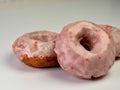 Cherry doughnut / donut with pink cherry glaze on top piled up on a white counter. Delicious baked goods Royalty Free Stock Photo