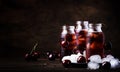 Cherry drink, cold juice with ice in bottles on vintage wooden table, summer fruit cocktail Royalty Free Stock Photo