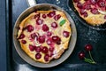 Cherry Dutch Baby, Puff German Pancake on Vintage Pans and Dark Background, Homemade Summer Dessert