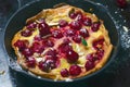 Cherry Dutch Baby, Puff German Pancake on Vintage Pans and Dark Background, Homemade Summer Dessert