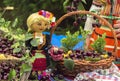 Doll in a typical Bulgarian folk costume to baskets of cherries. Royalty Free Stock Photo