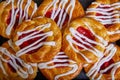 Cherry filled Danish pastry baked good with white frosting zigzagging swirl tray of pastries Royalty Free Stock Photo