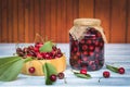 Fresh harvested cherry fruit and preserved fruit in jar Royalty Free Stock Photo