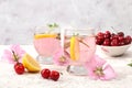 Cherry iced tea or mint and lemon cocktail, a refreshing summer drink recipe. Glass with apple fruit lemonade on light concrete Royalty Free Stock Photo