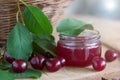 Cherry jam and basket of fresh cherries on a wooden table. Cherry in the nature Royalty Free Stock Photo