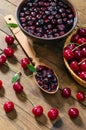Cherry jam and red cherries in a basket on a wooden table.