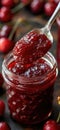 Cherry jam. Spoon scooping homemade cherry jam from a glass jar surrounded by fresh cherries Royalty Free Stock Photo