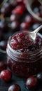 Cherry jam. Spoon scooping homemade cherry jam from a glass jar surrounded by fresh cherries Royalty Free Stock Photo
