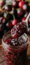 Cherry jam. Spoon scooping homemade cherry jam from a glass jar surrounded by fresh cherries Royalty Free Stock Photo