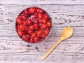 Cherry jam and wooden spoon on wooden table. Homemade jam from the fresh harvest of cherry berries. Flat lay. Royalty Free Stock Photo